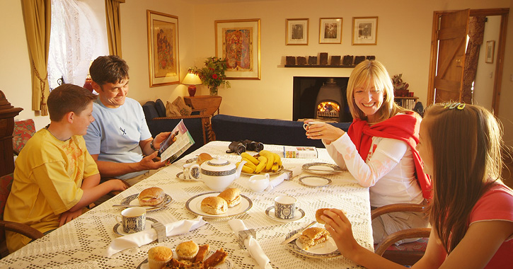 Family of four eating breakfast at a holiday cottage in County Durham.